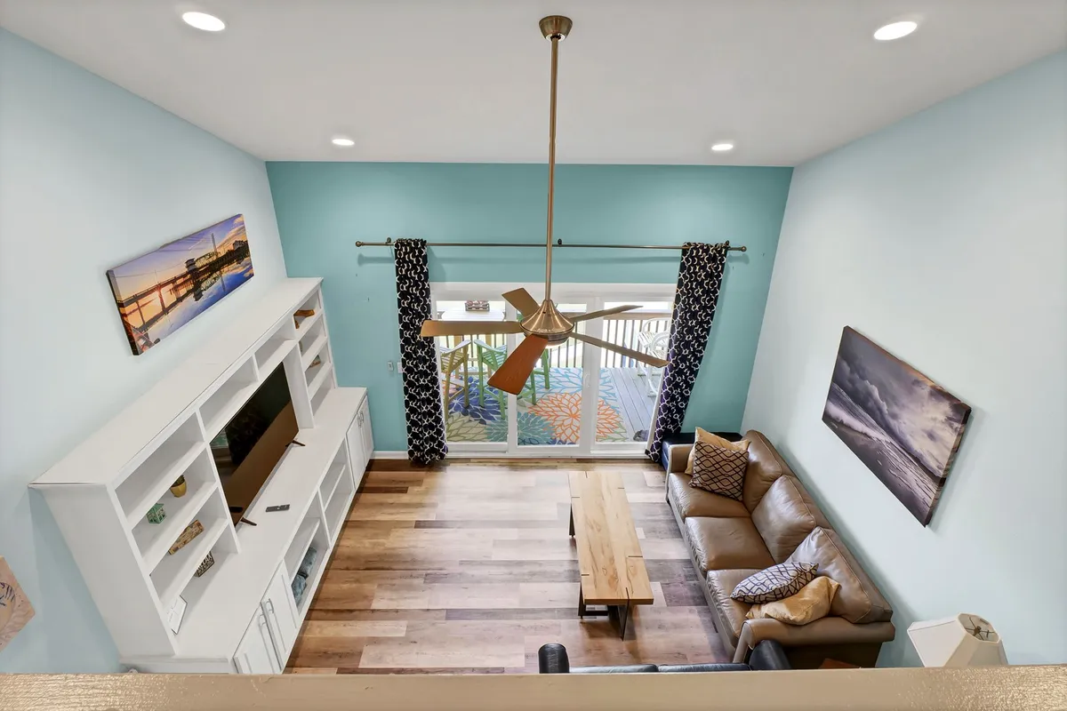 A cozy, inviting living room with a comfortable sofa, coffee table, television unit, and large windows that let in plenty of natural light. The space feels welcoming for both people and pets, with room to relax, socialize, and enjoy ocean views.